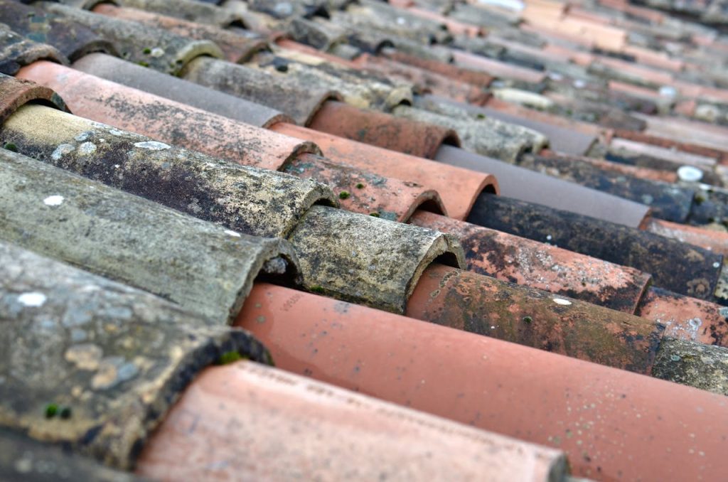close-up-shot-of-roof-tiles-6432077 Detailed close-up of weathered terracotta roof shingles in Provence, France.