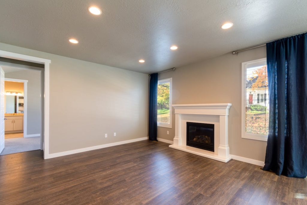 empty-interior-of-a-modern-house-10258624 Bright and modern living room featuring a sleek fireplace and hardwood floors.